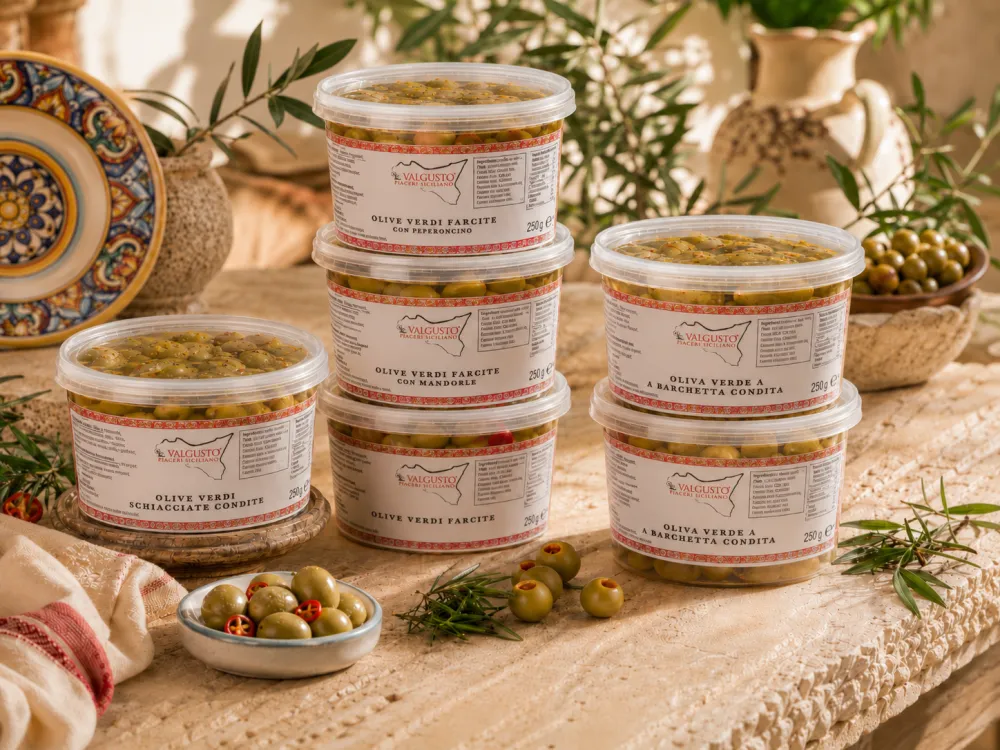Vaschette di olive verdi condite Valgusto su tavolo siciliano